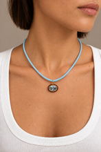 ALV Jewels EE Oval Cord Necklace — Blue, Blue cord, oval pendant, faceted blue center, brown surround, gold-tone accents