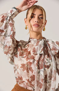 Vintage-inspired sheer blouse styled with dark denim and gold jewelry