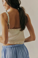 Back view of the cami featuring subtle embroidered eyelets and a cropped hem