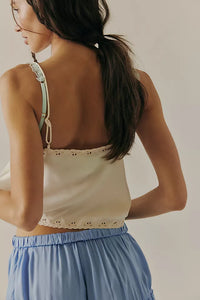 Back view of the cami featuring subtle embroidered eyelets and a cropped hem