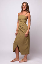 Lynx Pleated Midi Dress by En Saison in olive green, featuring asymmetrical pleats, spaghetti straps, and a front slit midi silhouette.