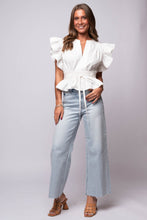 white flutter sleeve peplum top with split neckline, cinched waist, and tie belt