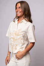 Neutral short sleeve cotton shirt with tonal embroidery, relaxed fit, and front buttons.