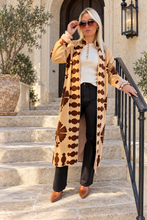 Sgt. Pepper Captain Duster in Leroy Brown, camel velvet with brown embroidery, modeled at a Mediterranean-style hotel.