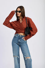 Brick red oversized wrap shirt with exaggerated sleeves and a tie-back waist