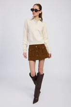 Model wearing ivory and navy mixed media sweater with collared shirt detail