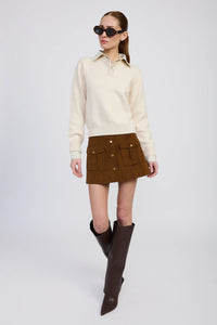Model wearing ivory and navy mixed media sweater with collared shirt detail