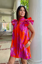 bright orange mini dress with large fuchsia floral print and ruffled sleeves,