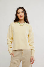 Cozy yellow pullover paired with textured neutral pants