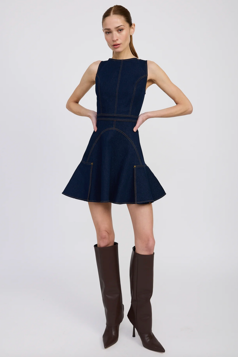 Model wearing a navy blue dress with brown knee-high boots 