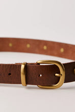 Brass studded belt adding shape and texture to an outfit
