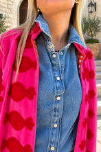 Sgt. Pepper Crew Jacket in Cherry Bomb, pink velvet with red embroidery, modeled at a Mediterranean-style hotel.