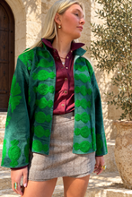 Sgt. Pepper Crew Jacket in Green Onions, emerald velvet with bright green embroidery, modeled at a Mediterranean-style hotel.