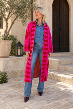 Sgt. Pepper Captain Duster in Cherry Bomb, pink velvet with red embroidery, modeled at a Mediterranean-style hotel.