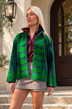 Sgt. Pepper Crew Jacket in Green Onions, emerald velvet with bright green embroidery, modeled at a Mediterranean-style hotel.