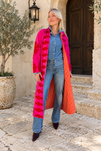 Sgt. Pepper Captain Duster in Cherry Bomb, pink velvet with red embroidery, modeled at a Mediterranean-style hotel.