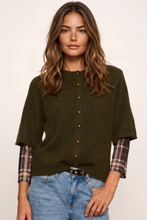 Sanctuary Short Sleeve Cardigan in Kalamata olive, model wearing the button-front knit over a plaid shirt.